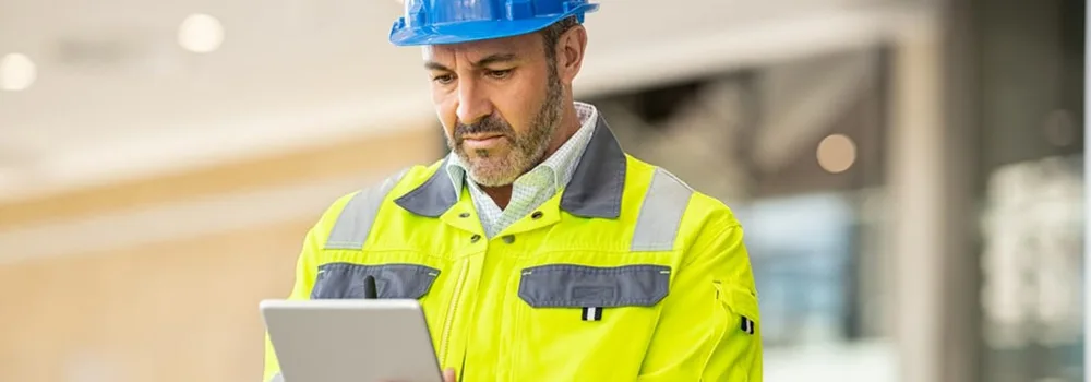 Project manager reviewing a certificate of insurance on a tablet before a sub starts work