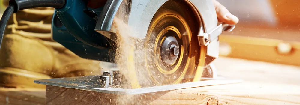 Carpenter cutting lumber on a job where added work needs a change order
