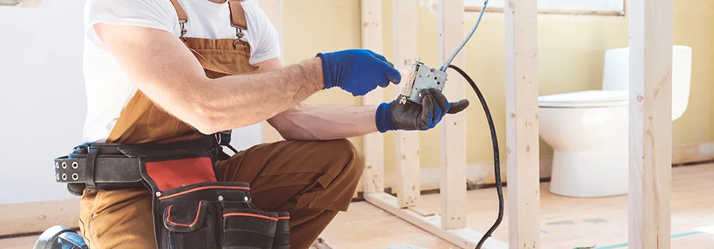 Electrician wiring an outlet box during a remodel