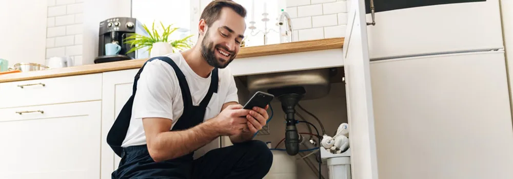 A plumber walks the job with the customer; a clean CRM handoff means the crew already knows what was sold
